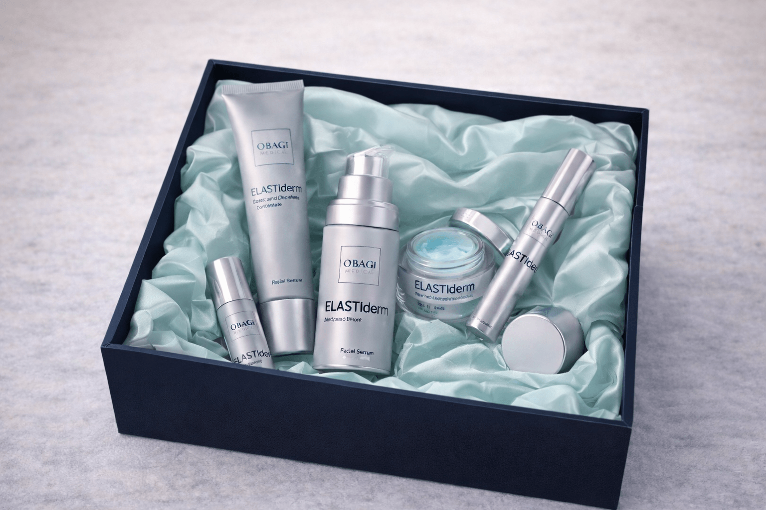 Set of skincare products in a box with ELASTIderm branding on a light gray background