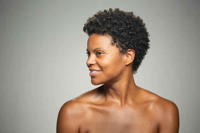 Woman with short, styled hair against a gray background