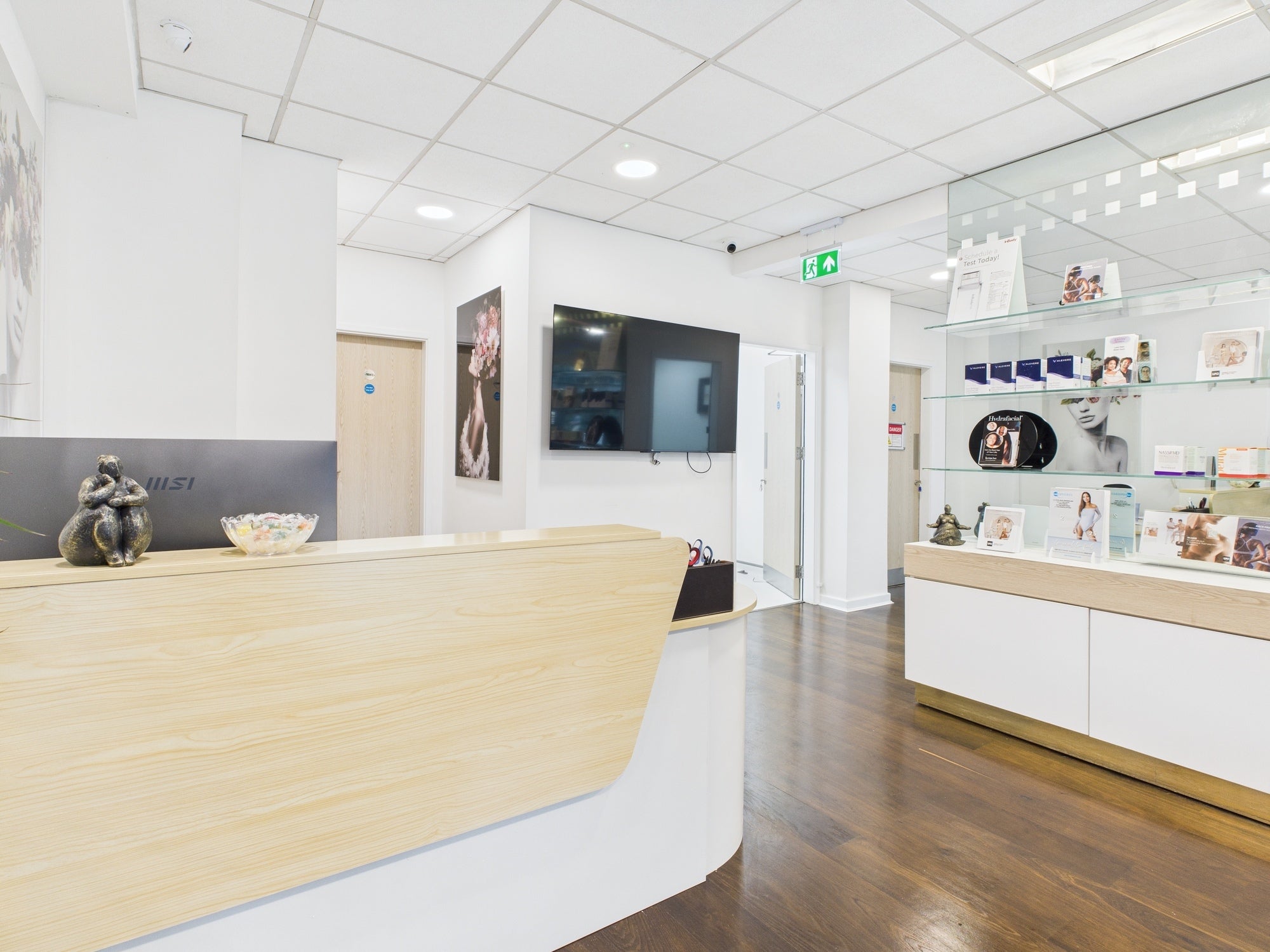 Skincare clinic reception area with wooden desk and product display shelves