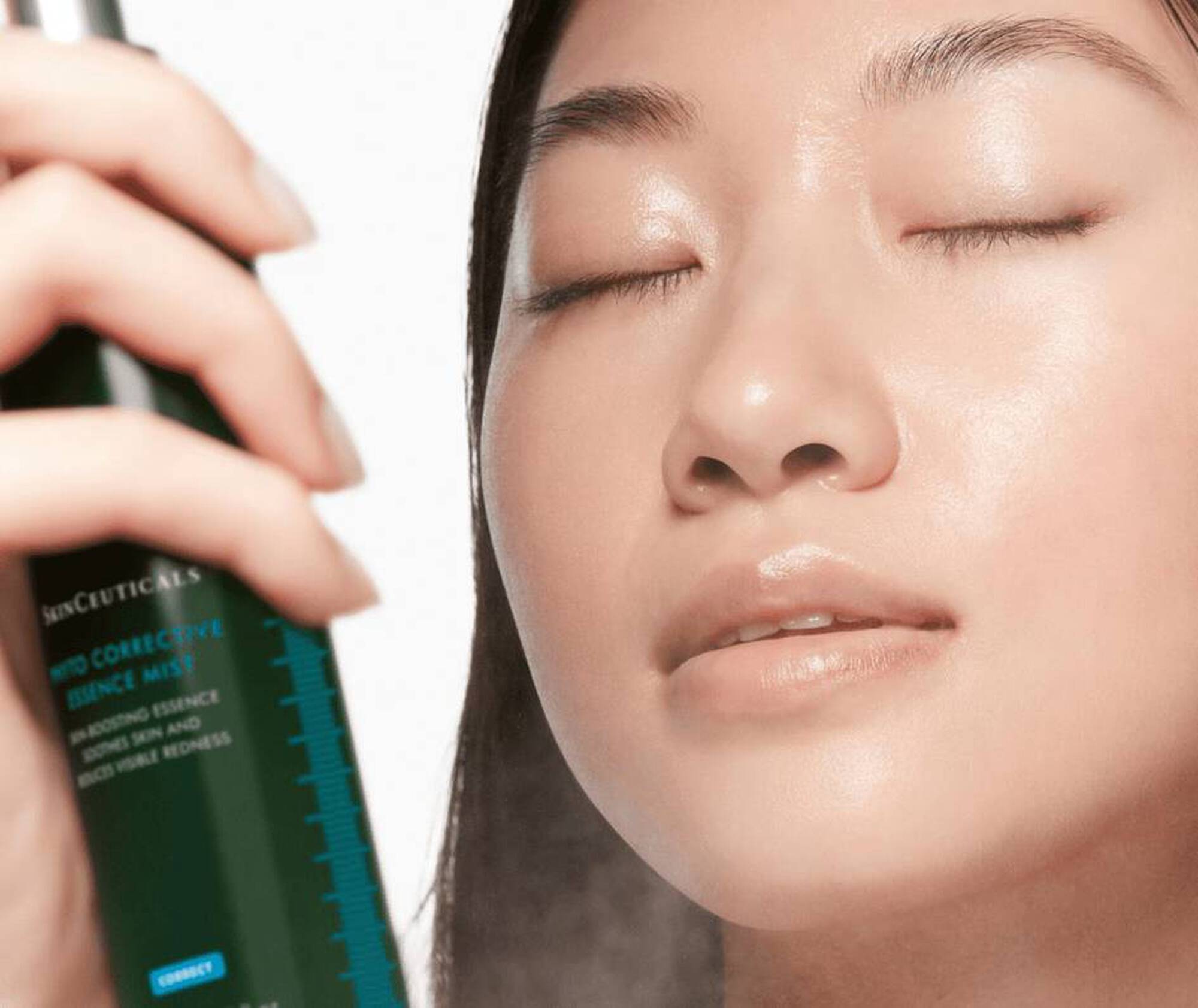 Person holding a skincare product near their face