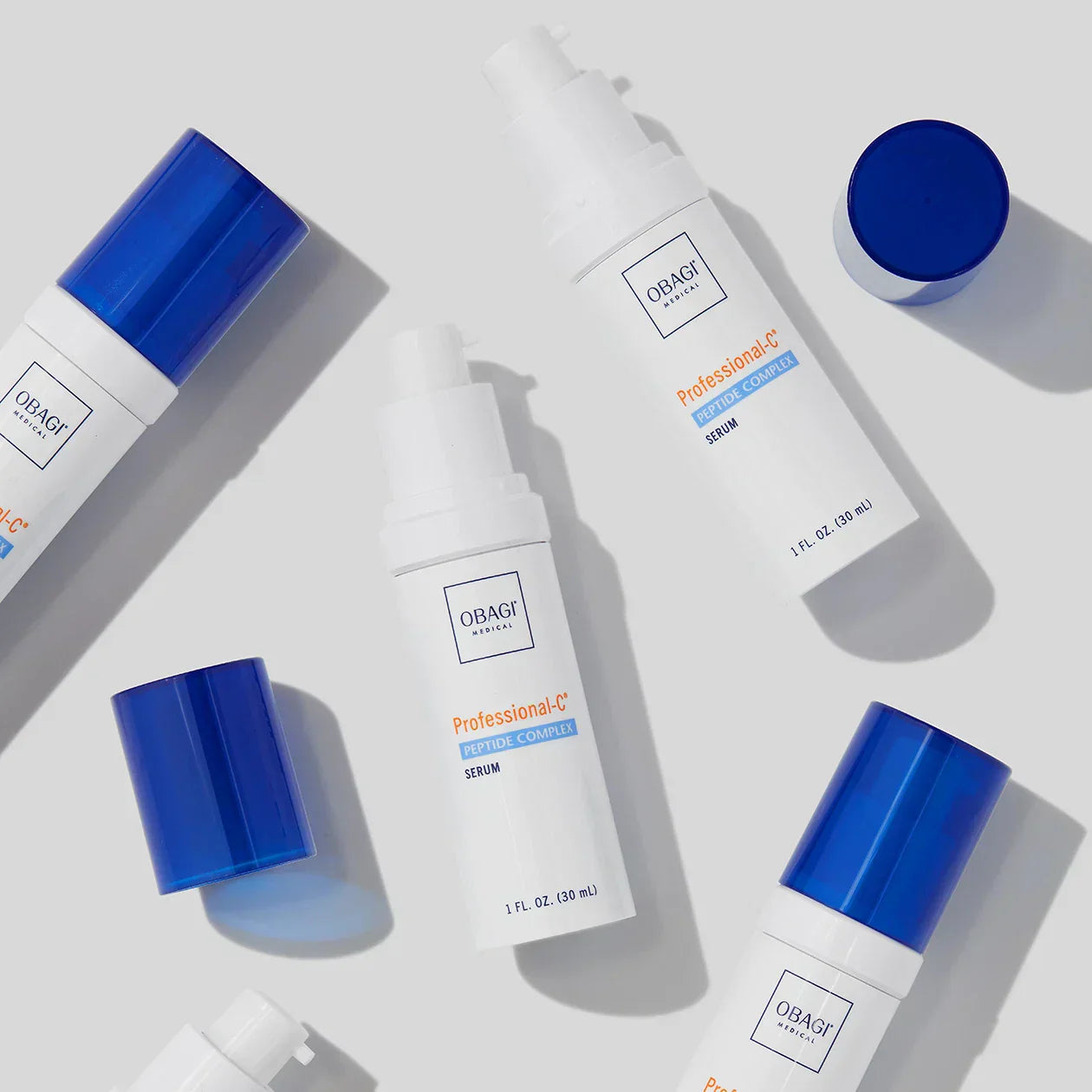 Obagi skincare bottles with blue caps on a light gray background