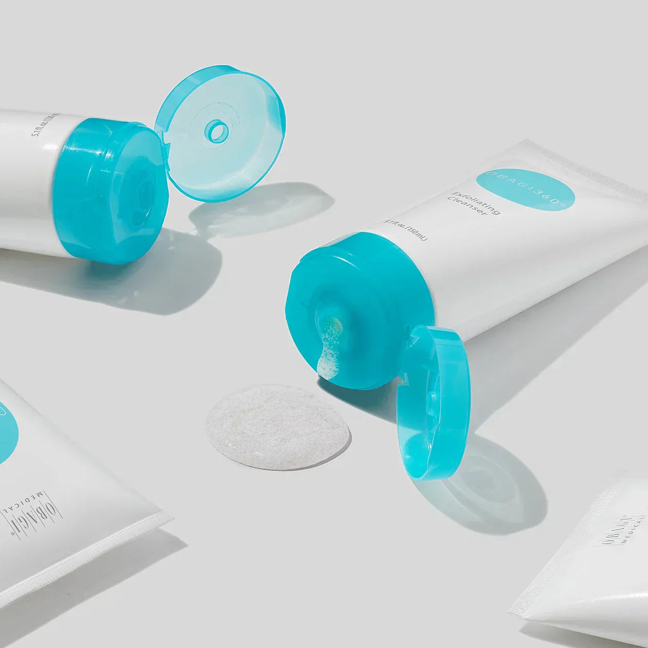 White tubes with blue caps on a light gray background