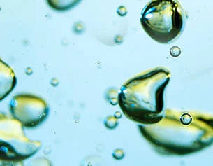 Close-up of oil droplets on water with a blue tint
