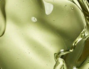 Close-up of a greenish-brown liquid with a gold chain