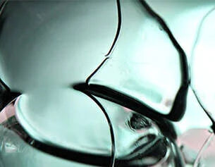 Close-up of a broken glass object with a reflective surface.