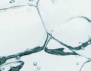 Close-up of water droplets and splashes on a light blue background