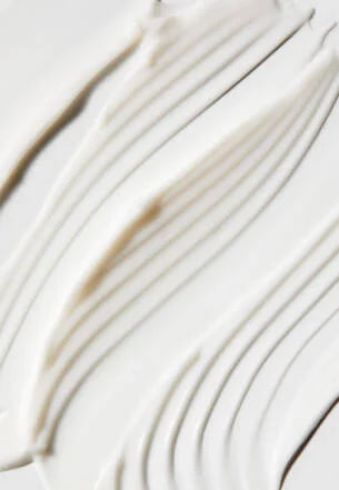 Close-up of a white fabric with a brown stain on a light background