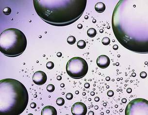 Close-up of purple and clear bubbles on a purple background