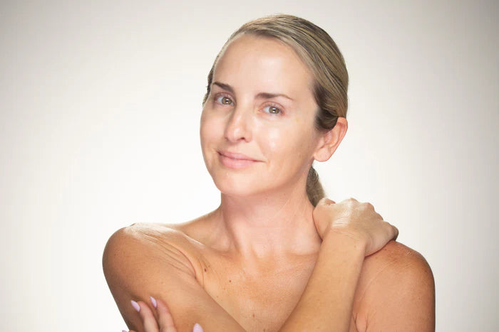 Woman with a bare shoulder against a plain background
