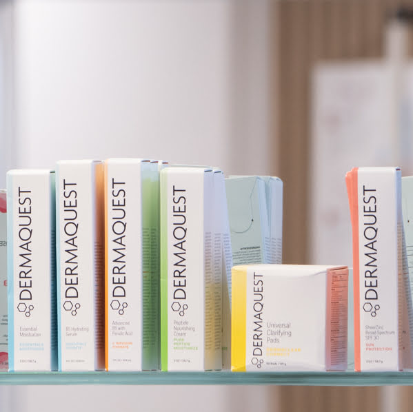 Row of Dermaquest skincare products on a shelf with a blurred background