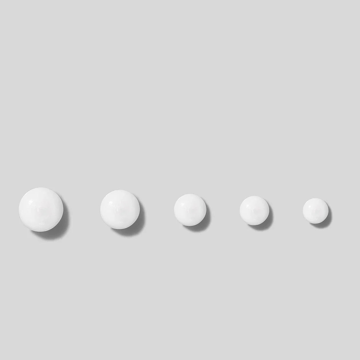 Five white spherical objects on a light gray background