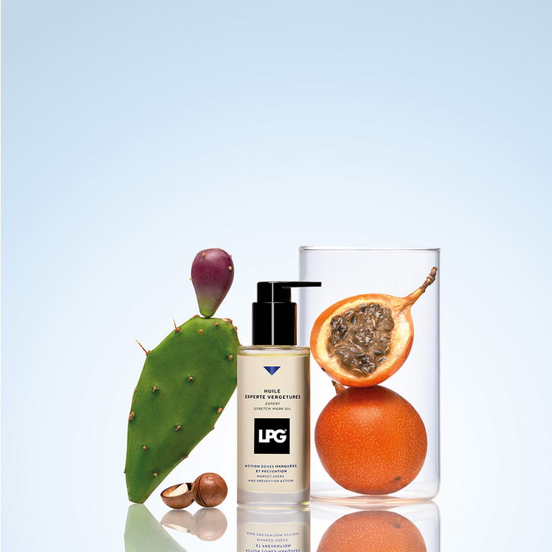 expert stretch mark oil with a cactus, orange, and passion fruit on a reflective surface.