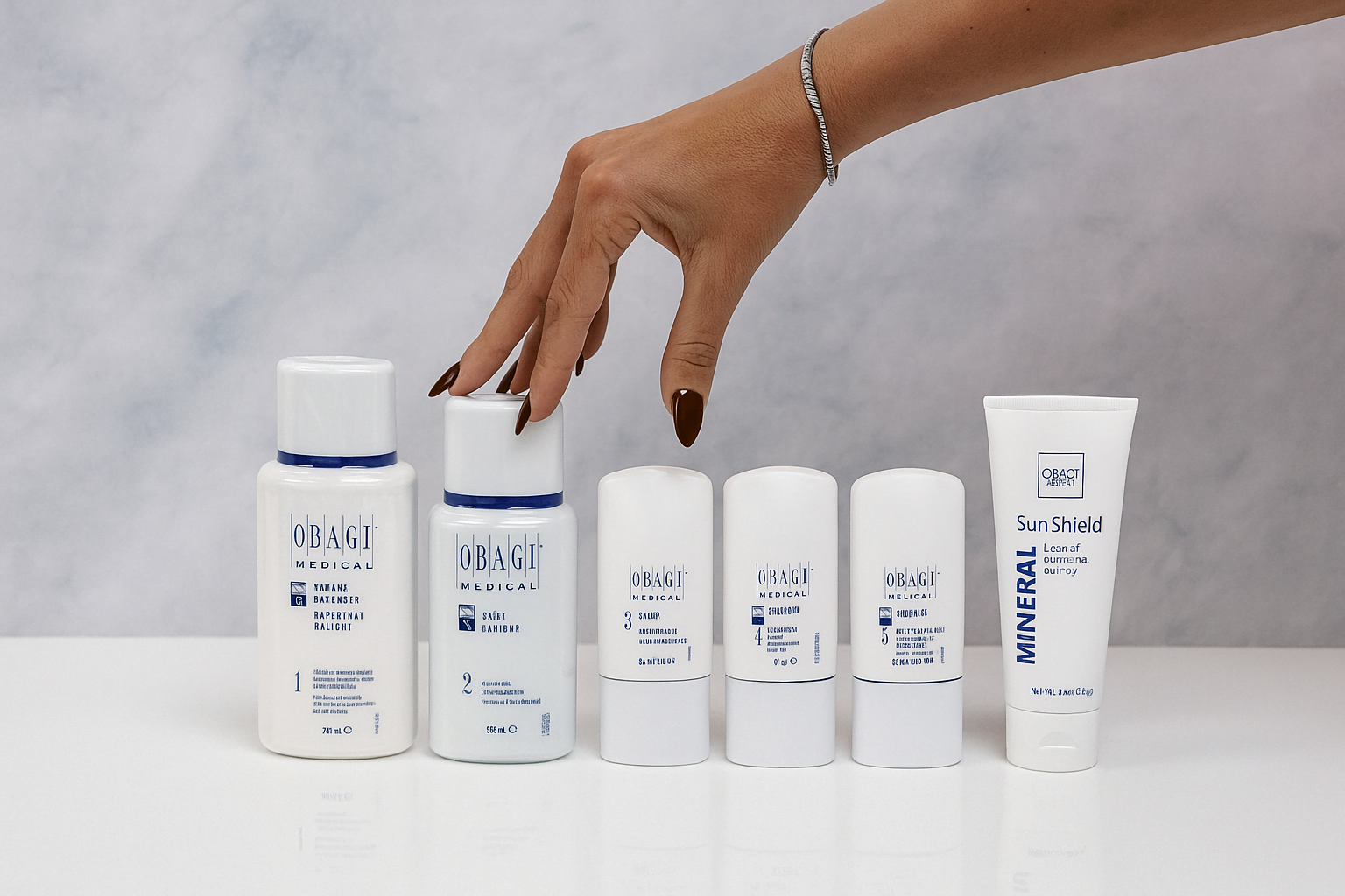 Hand reaching for a bottle of Obagi skincare products on a gray background