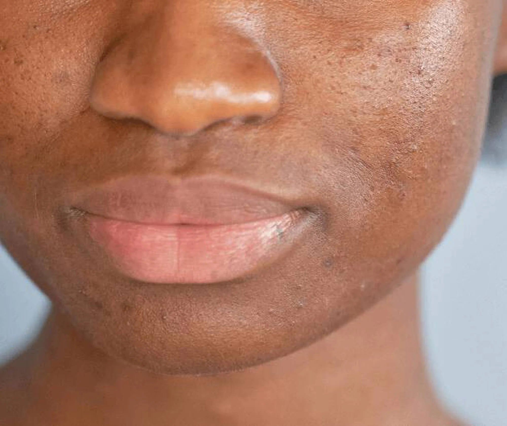 Close-up of a person's face with a neutral expression on a light blue background