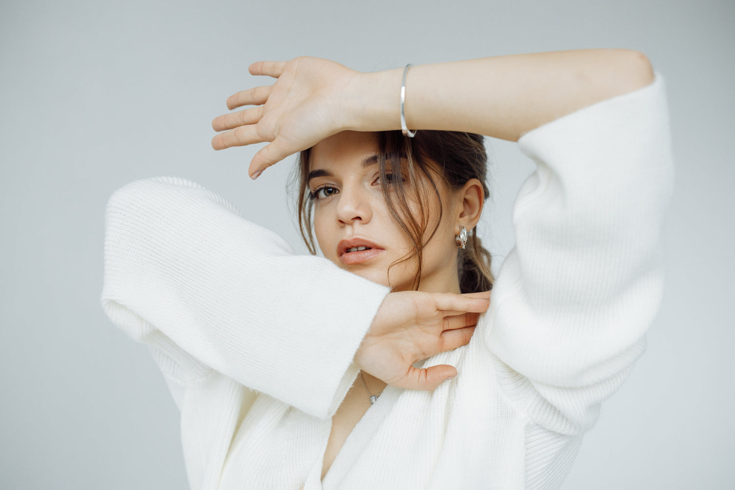 Woman wearing a white coat against a plain background